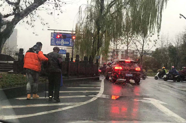 市心桥头,老人雨天闯入车流中,路人拍下暖心一幕!