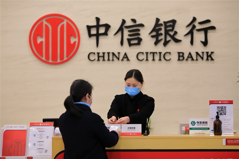 图为中信银行杭州萧山支行工作人员正在指导客户办理业务